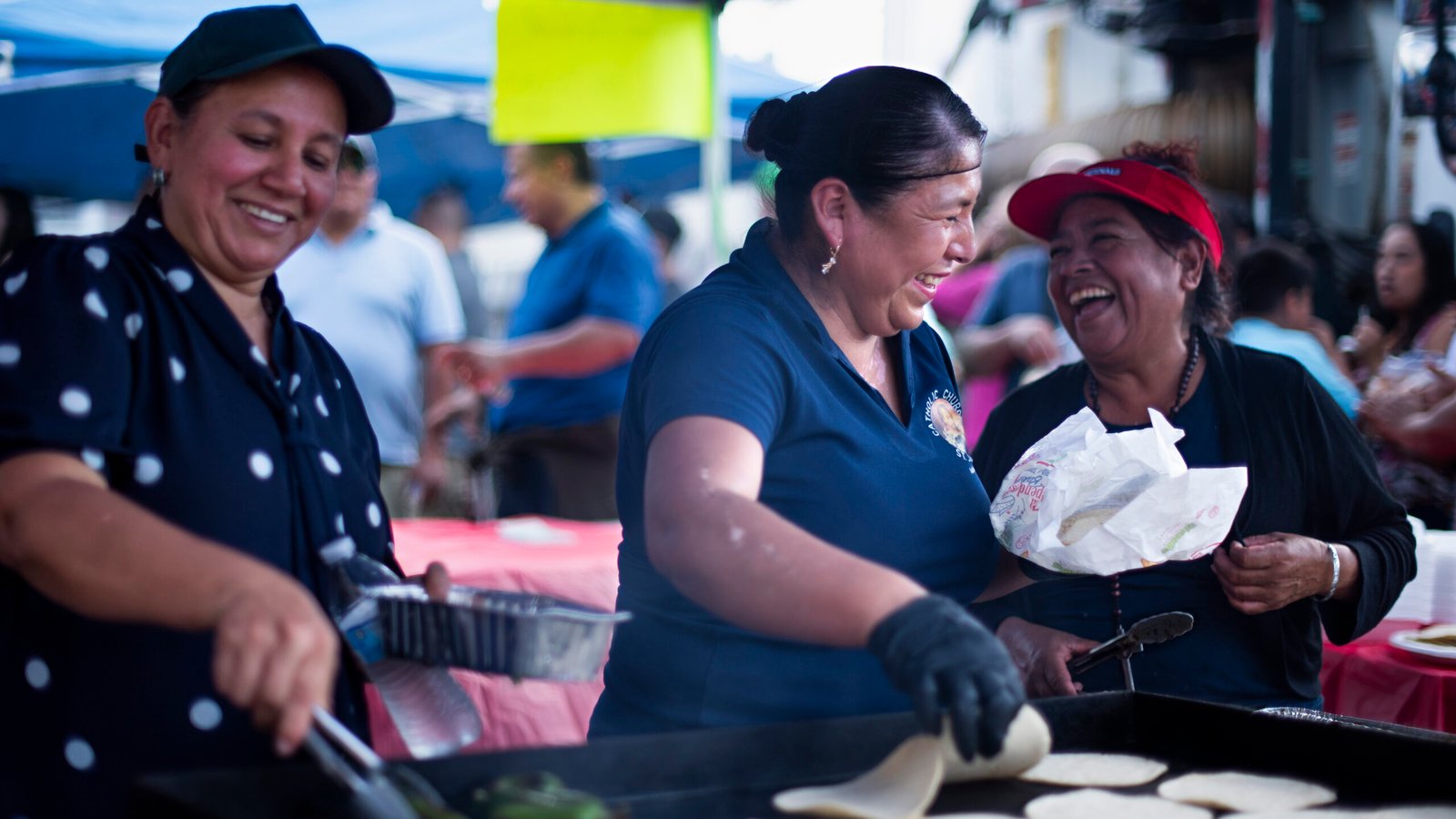Estelle, Andrea, and Carmen (left to right) prepare tacos while sharing a laugh together at the Fall Festival in downtown Asheboro, North Carolina on Saturday, Oct. 4, 2025. (Photo by Sollyn Lindsay).