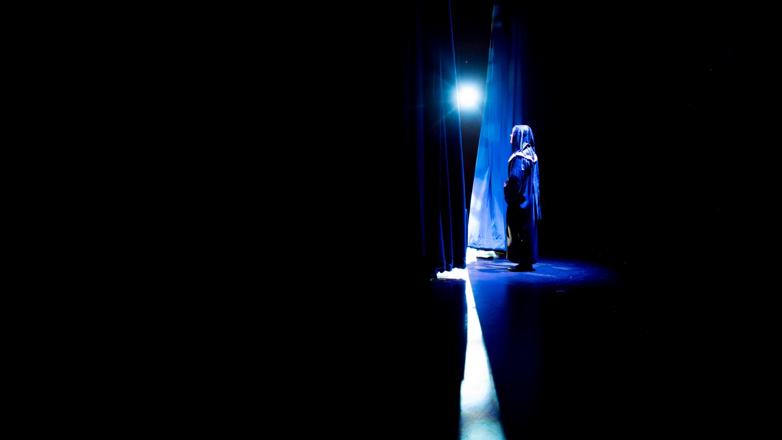 Caldwell Academy student Natalie Highfill assumes the role of Mother Abbess in "The Sound of Music" while the curtains are pulled back to start the show at the Virginia Somerville Sutton Theatre at the Well-Spring retirement community in Greensboro, NC on Wednesday, Nov. 5, 2025. Due to a lack of space at their school, the retirement home offers the school the theatre to perform their shows at. (Photo by Sollyn Lindsay).